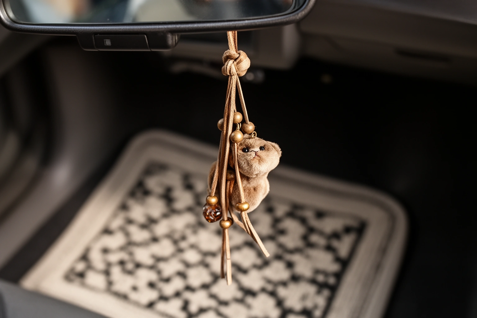 Small rearview mirror charm and patterned floor mat as budget car interior decor
